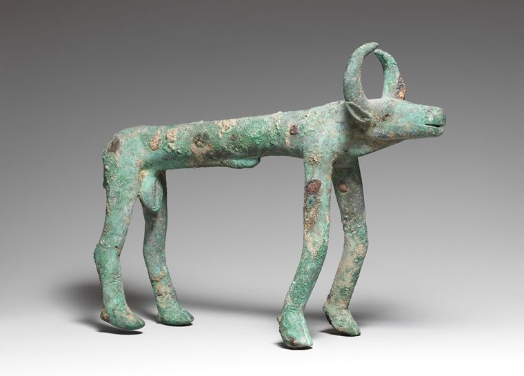 An ancient green and white bronze in the form of a thin buffalo-like beast