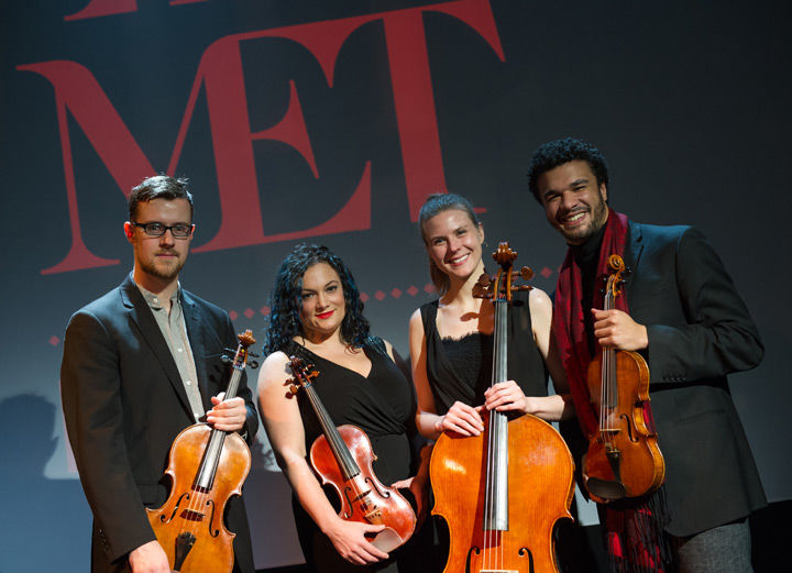 Four members of a string quartet pose with their instruments