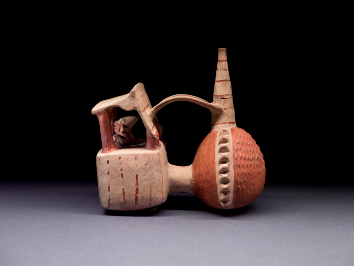 Ancient Peruvian ceramic vessel in the shape of a bivalve shell with a deep-sea diver near the front
