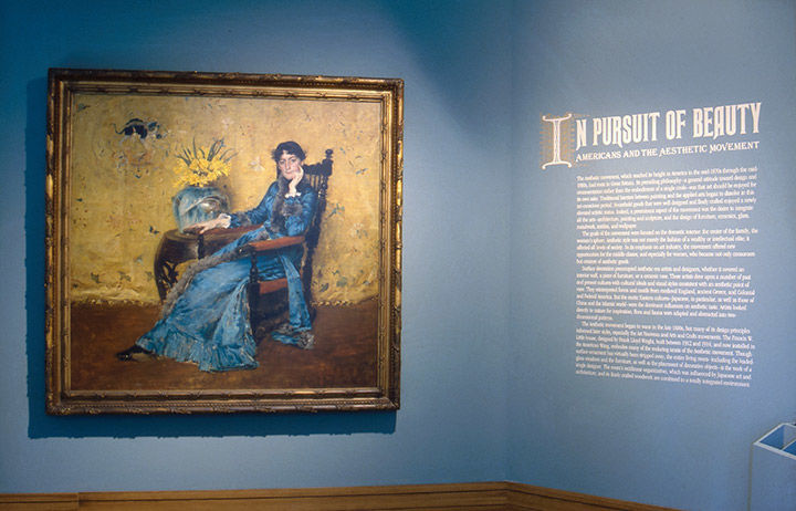Entrance to 1986 exhibition, with a painting of a woman and a large wall text