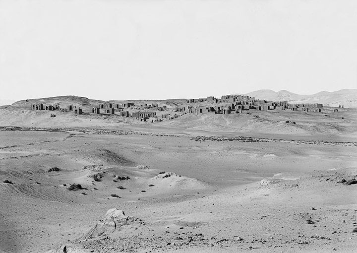 Black-and-white archival photograph of the desert with Kharga Oasis in the distance