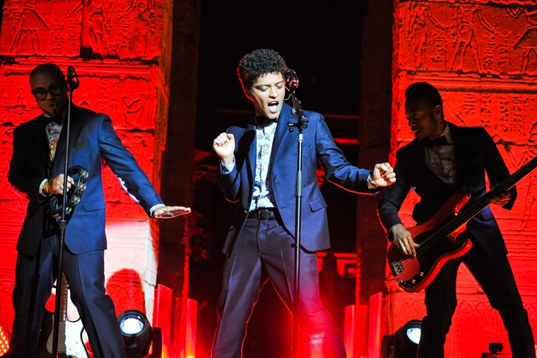Bruno Mars performs in front of the Temple of Dendur, lit in red hues, at the 2012 Met Gala