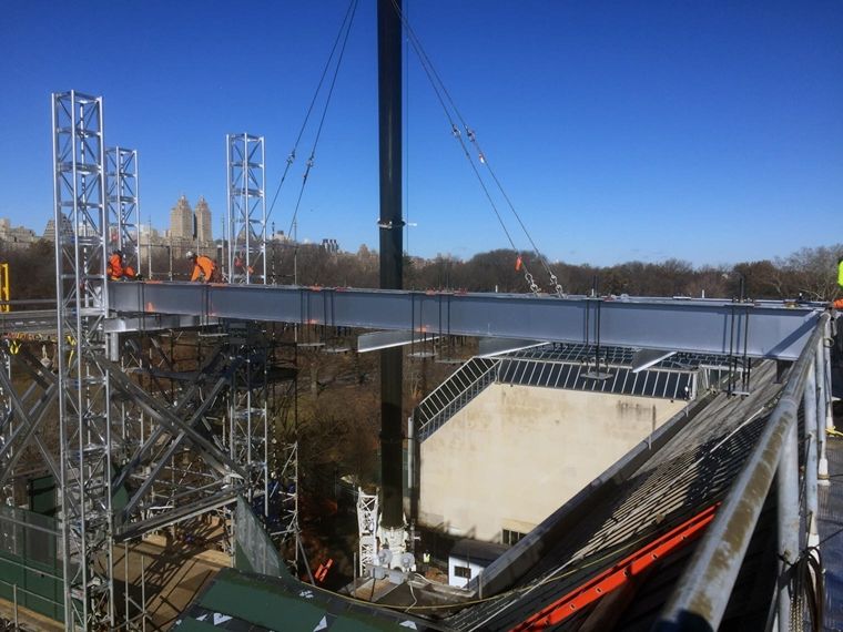 View of construction work taking place above The Met's roof, with the Central Park skyline in the background