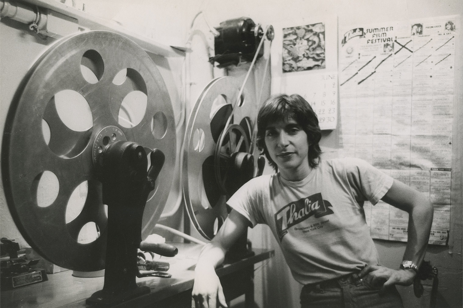 A black-and-white photograph of the author, Robin Schwalb, standing beside a rewinder at the Thalia Theater in New York City, circa 1978.
