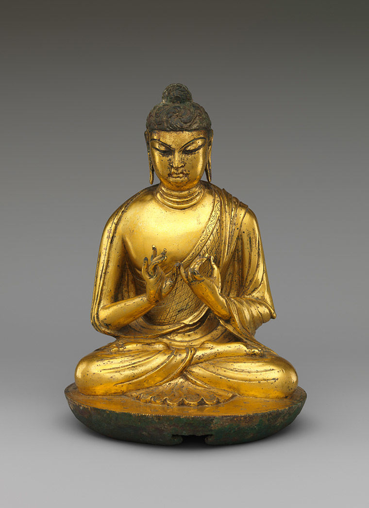 A golden sculpture of a Buddha sitting padmasana