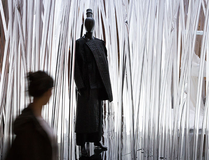 Woman looking at an exhibition installation of costumes