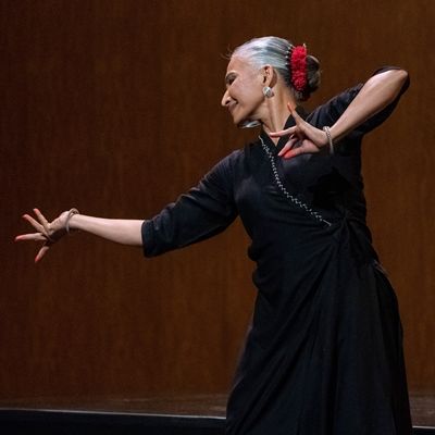 Bijayini Doha fills the frame with dancing with the right arm outstretched and the left arm bent toward the chest.