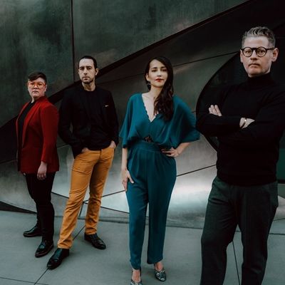 The four members of the Catalyst Quartet face the camera at various angles, against a silvery metallic background.