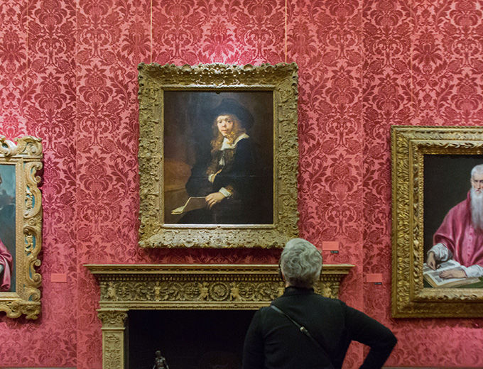 Visitor in a gallery studying a painting 