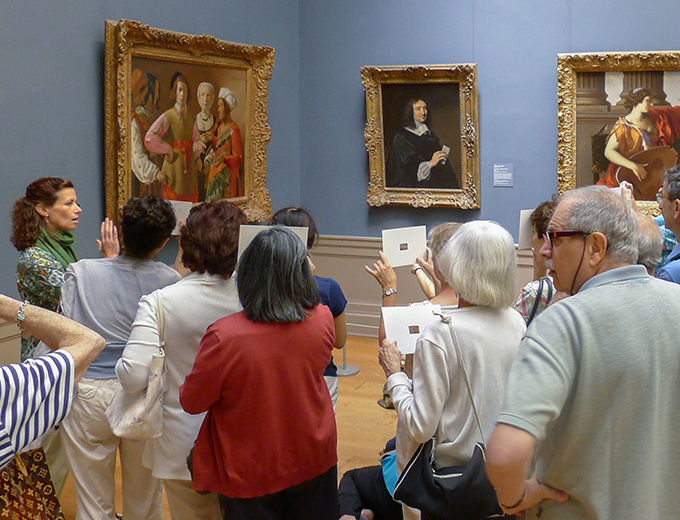 Visitors in the European paintings gallery listening to a museum educator during a gallery talk