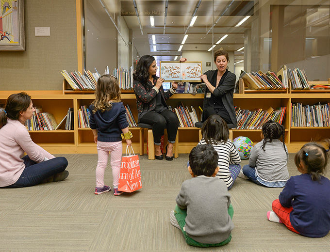 Young children sitting in a library listening to a story 