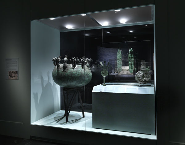View through one of the double-sided cases of Cauldron with griffin and siren attachments, SAL. T.79/202, and other objects from the Department of Antiquities, Cyprus