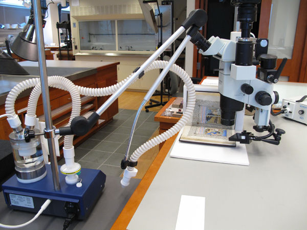 Figure 6.  An Ultrasonic consolidation unit and a binocular microscope with a bound manuscript strapped to its 90 degree cradle