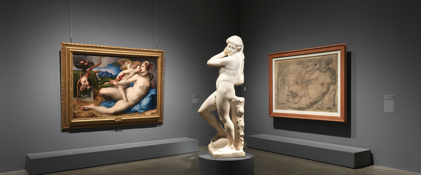 Installation view of the exhibition 'Michelangelo: Divine Draftsman and Designer' featuring a marble sculpture and a full-scale cartoon by Michelangelo