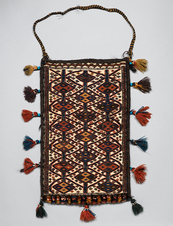 Woven bag with shoulder-strap and tufted fringe