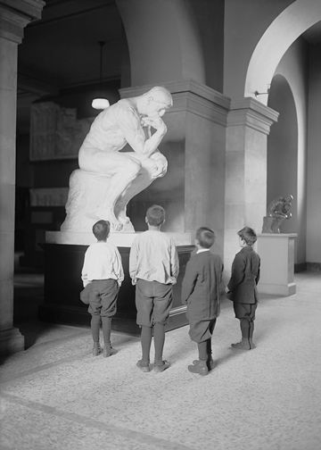 A group of children view Auguste Rodin's sculpture The Thinker