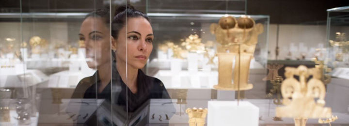 Artist Teresita Fernandez observes a vitrine of gold jewelry from the ancient Americas