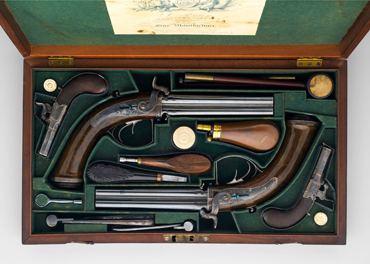 Two four-barrelled pistols, displayed in a custom case