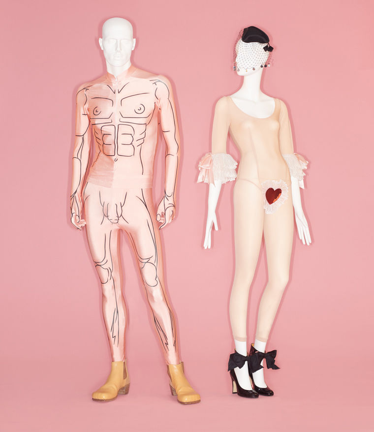 One men's ensemble and one woman's ensemble, both form-fitting garments made to replicate each body's form