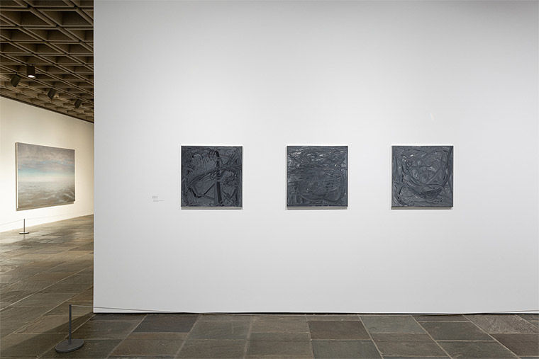Installation view of Gerhard Richter: Painting After All featuring three small, square abstract paintings in gray
