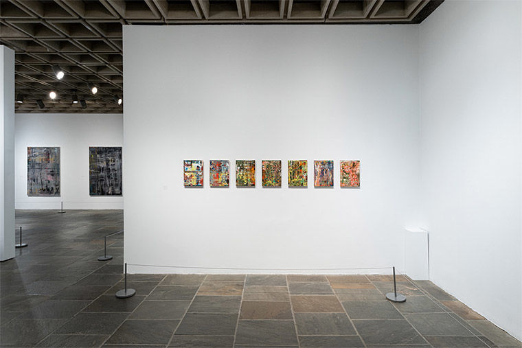 Installation view of Gerhard Richter: Painting After All featuring seven small, colorful abstract canvases in sequence