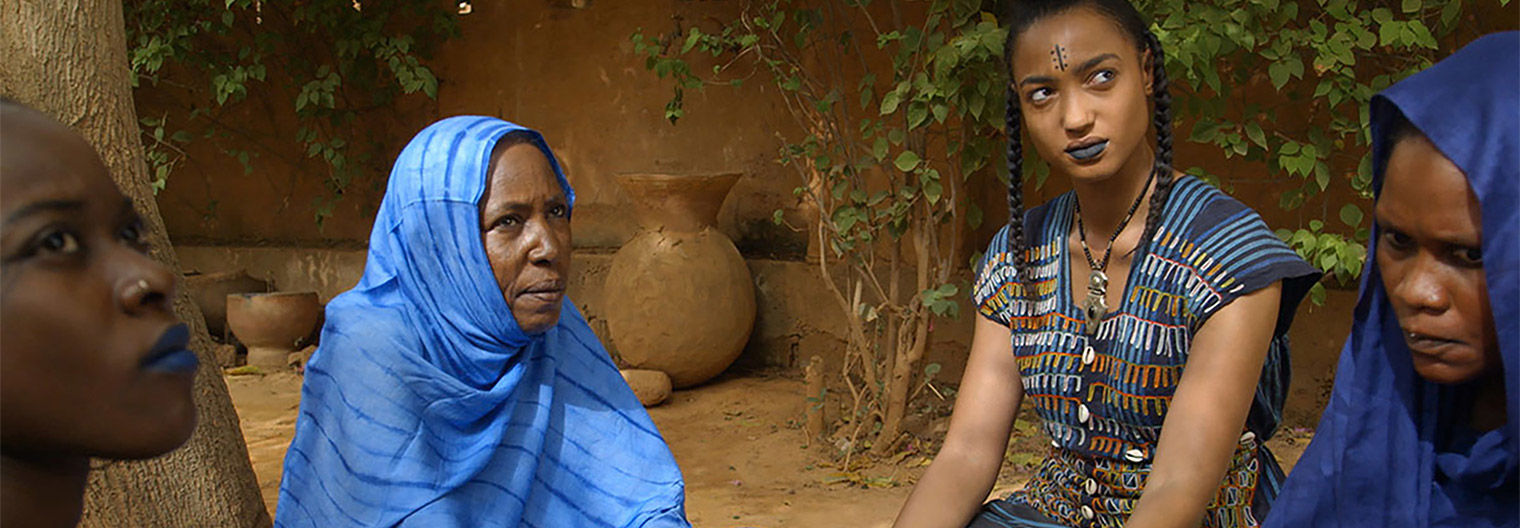 A still from a film depicting four women seated in a circle