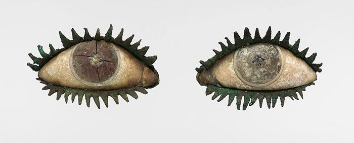 Stone statues of two eyes with green eyelashes