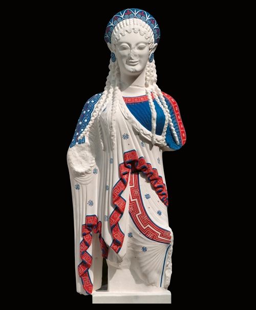 Statue of a woman with curly hair, closed eyes, and dark blue and a pink floral headband and dress