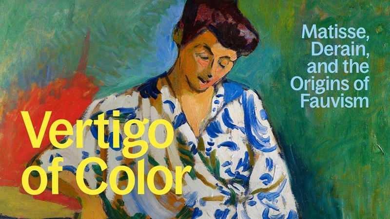 A woman with a white and blue robe sitting amid a green background