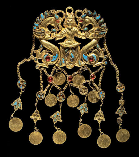 One of a pair of pendants depicting a "Dragon master"