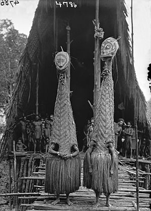 Two Basketry Figures in front of <i>Daima</i> (Longhouse) at Tovei, Urama