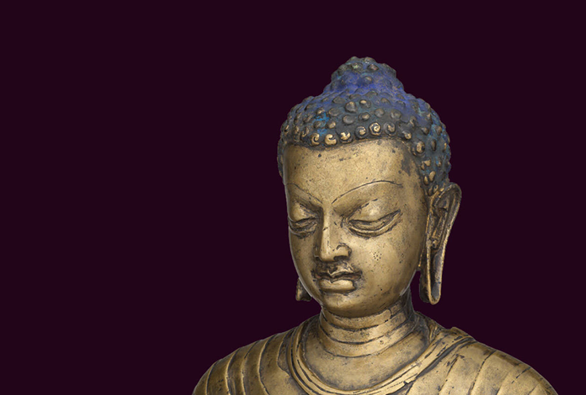 The head of a bronze statue of the Buddha over a dark purple background
