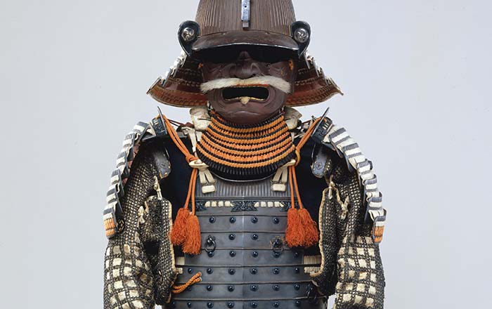 Image of Japanese armor. It features a kusazuri (skirt) with an extremely rare color scheme of silk lacings in red, yellowish-green, black, and white. The mon (heraldic badge), in the form of three whirling commas (mitsudomoe mon).