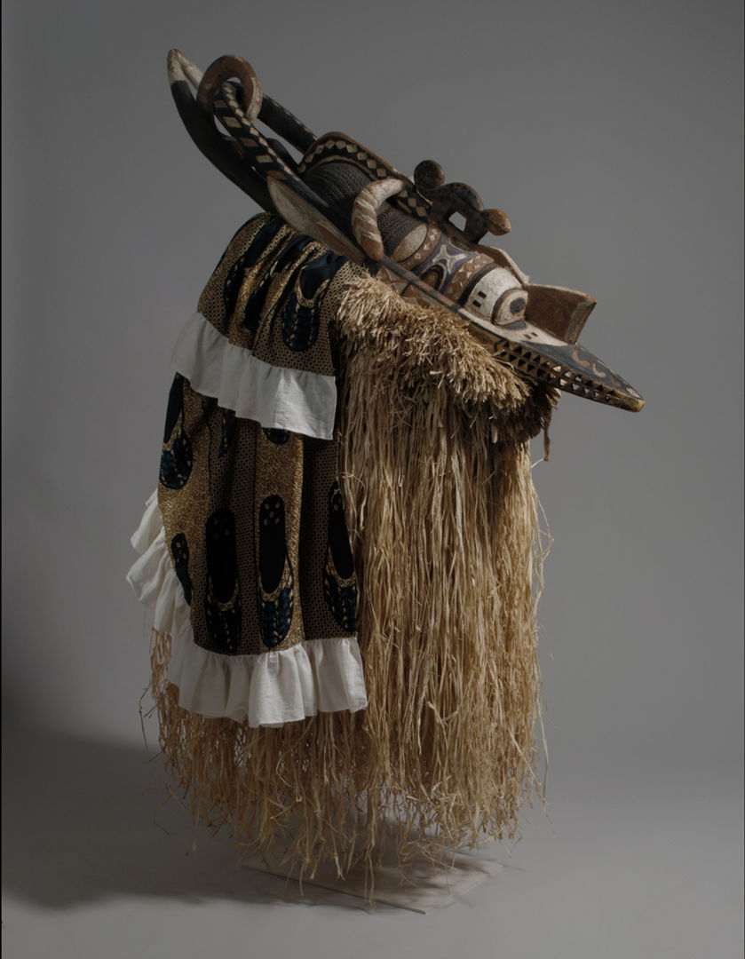 An African mask made of carved and painted wood, fabric, and plant fibers