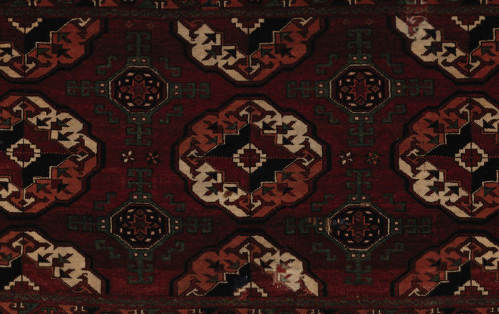 art assignment class 6 A close-up of a dark brown, burgundy, olive-green and white carpet decorated in a repeating pattern of geometric motifs
