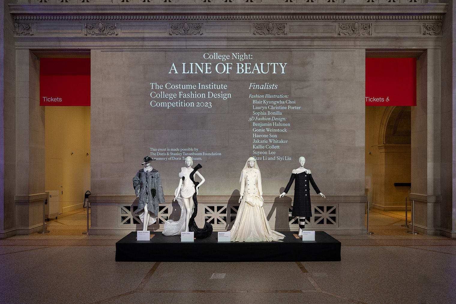 Several dressed mannequins sporting fashion designs on a platform.