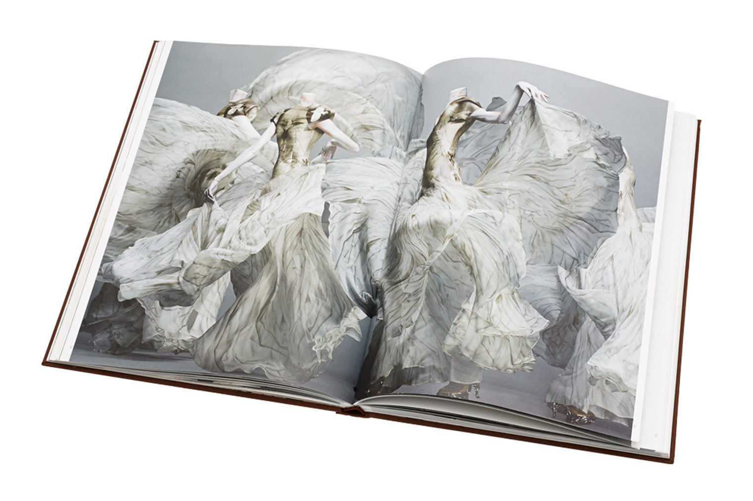 A picture of a book depicting fashion designed by Alexander McQueen