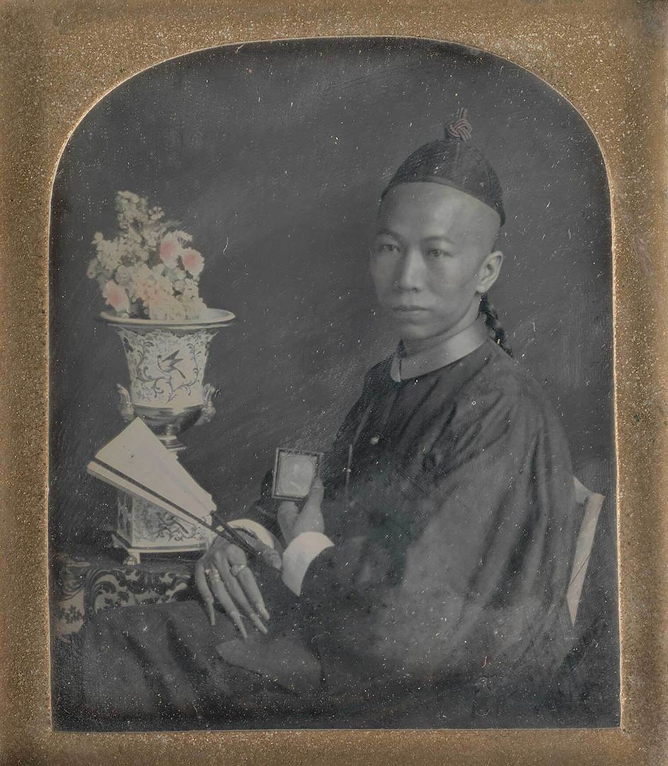 A daguerreotype of a young man holding a fan