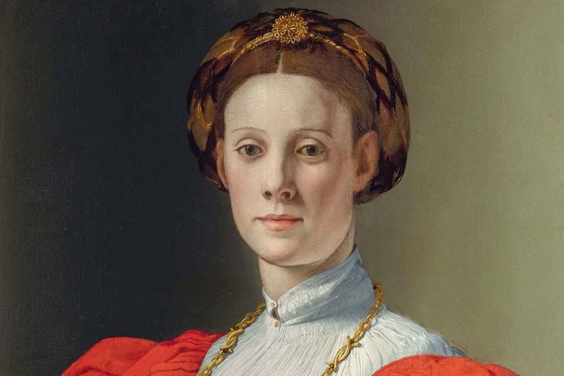 Detail from Portrait of a Woman with a Lapdog by Branzino. A painting of an ornately dressed woman with a small dog in her lap.