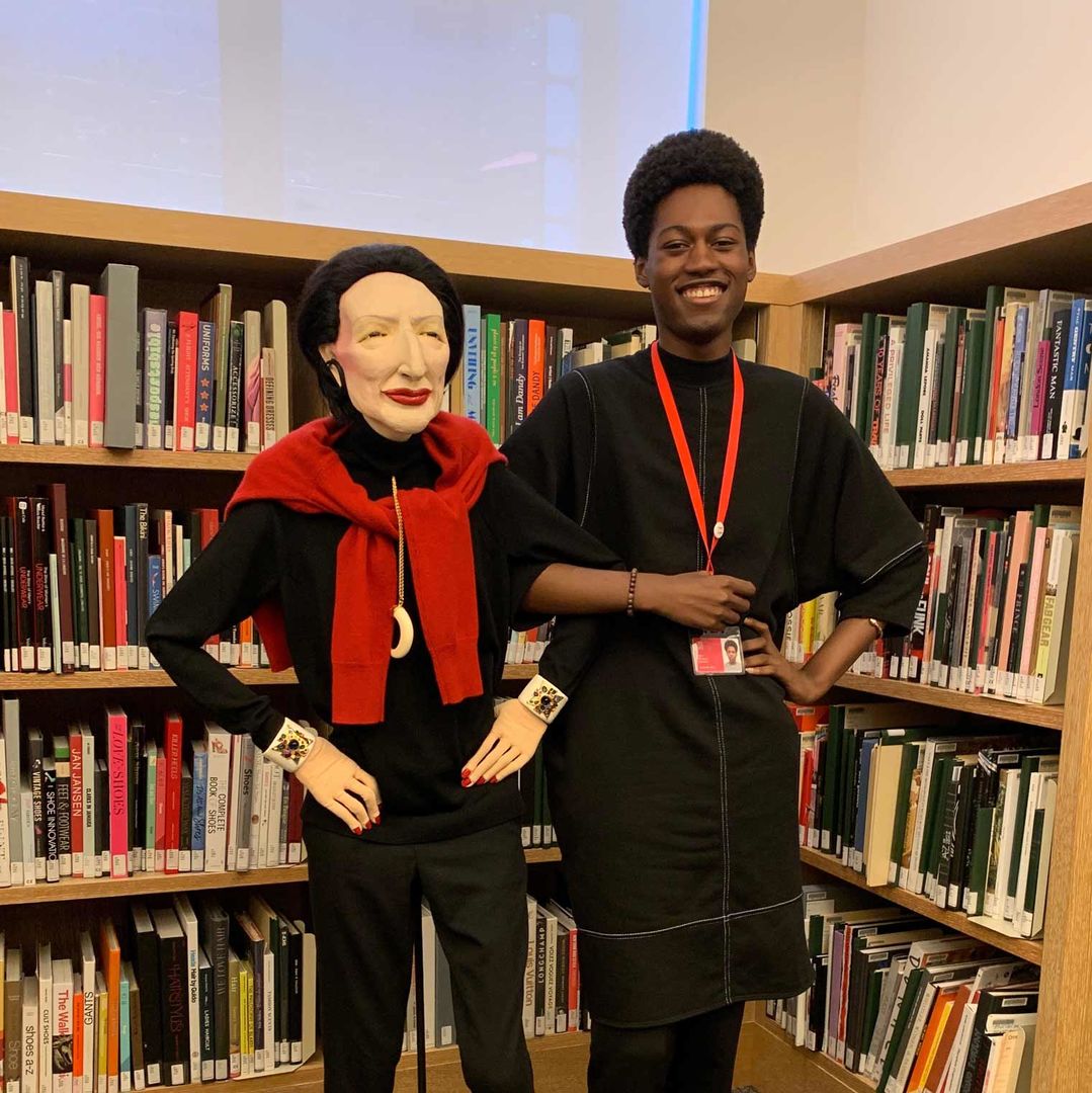 Kai Toussaint Marcel arm-in-arm with a Diana Vreeland doll in the Costume Institute Library