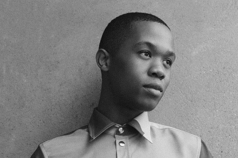 A black-and-white photo of designer Thebe Magugu looking off to the side