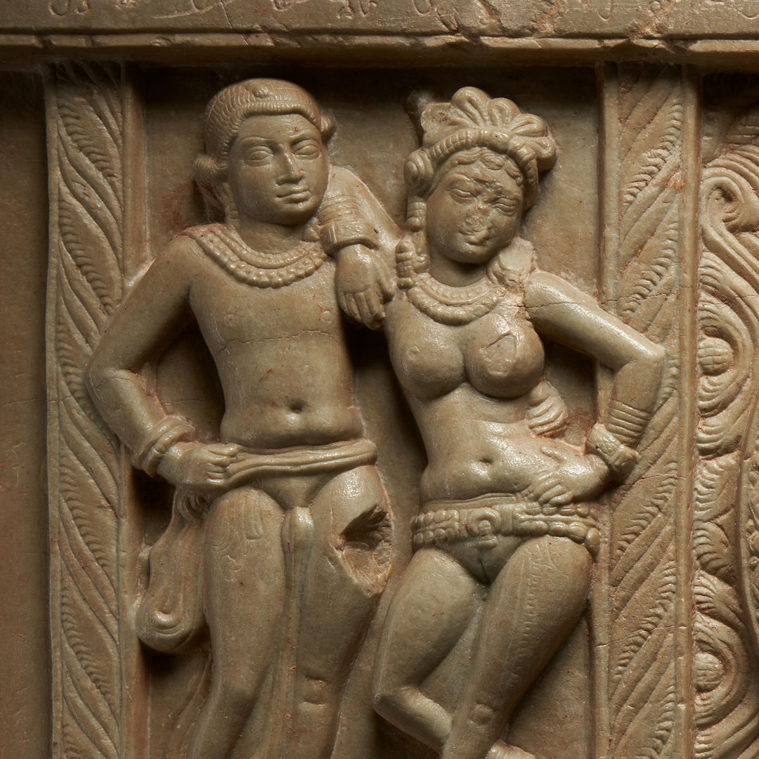 Limestone carving of a male and female figure