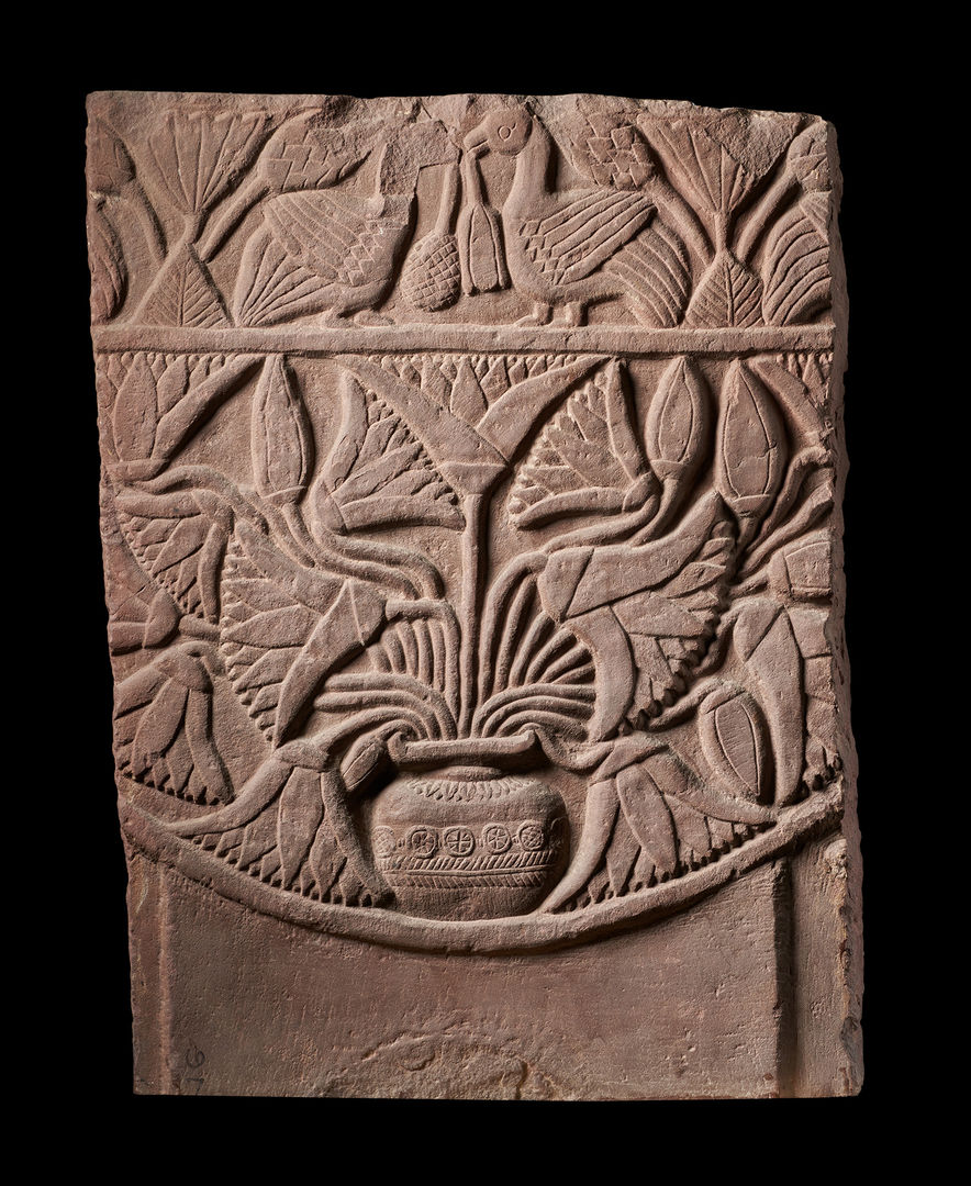 Sandstone carving of a vase with flowers