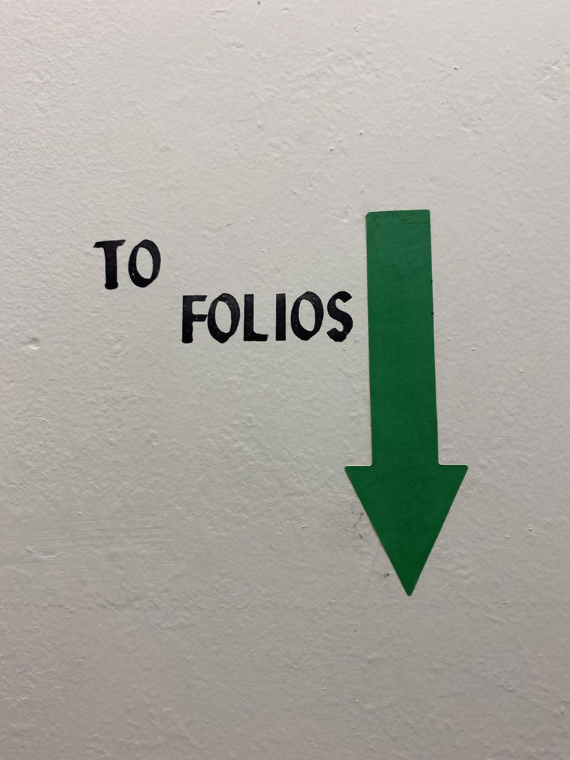 Library signage reading "to folios" with an arrow pointing down
