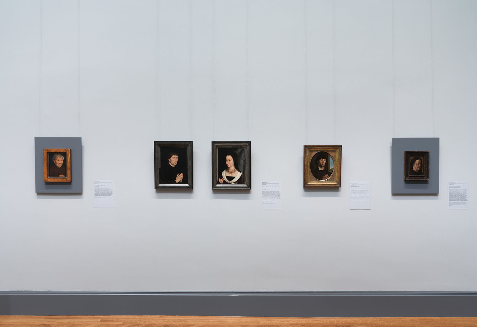 Five portraits hanging in the “Faces of the Renaissance” gallery in European Paintings, 1300-1800. The paintings are lit from above, and the wall behind them is painted a light blue-gray.