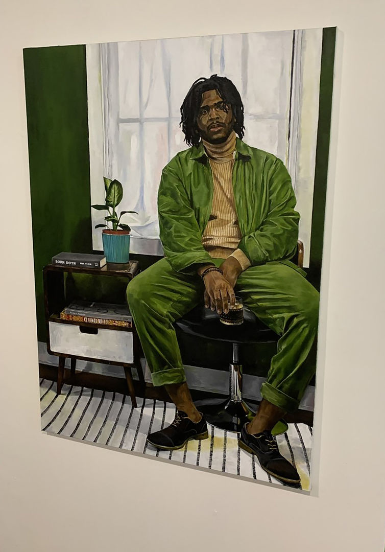 Painting of a dark-skinned man sitting on a stool wearing a yelow turtle neck and green jacket and pants. He is holding a glass and is sitting in front of a window.
