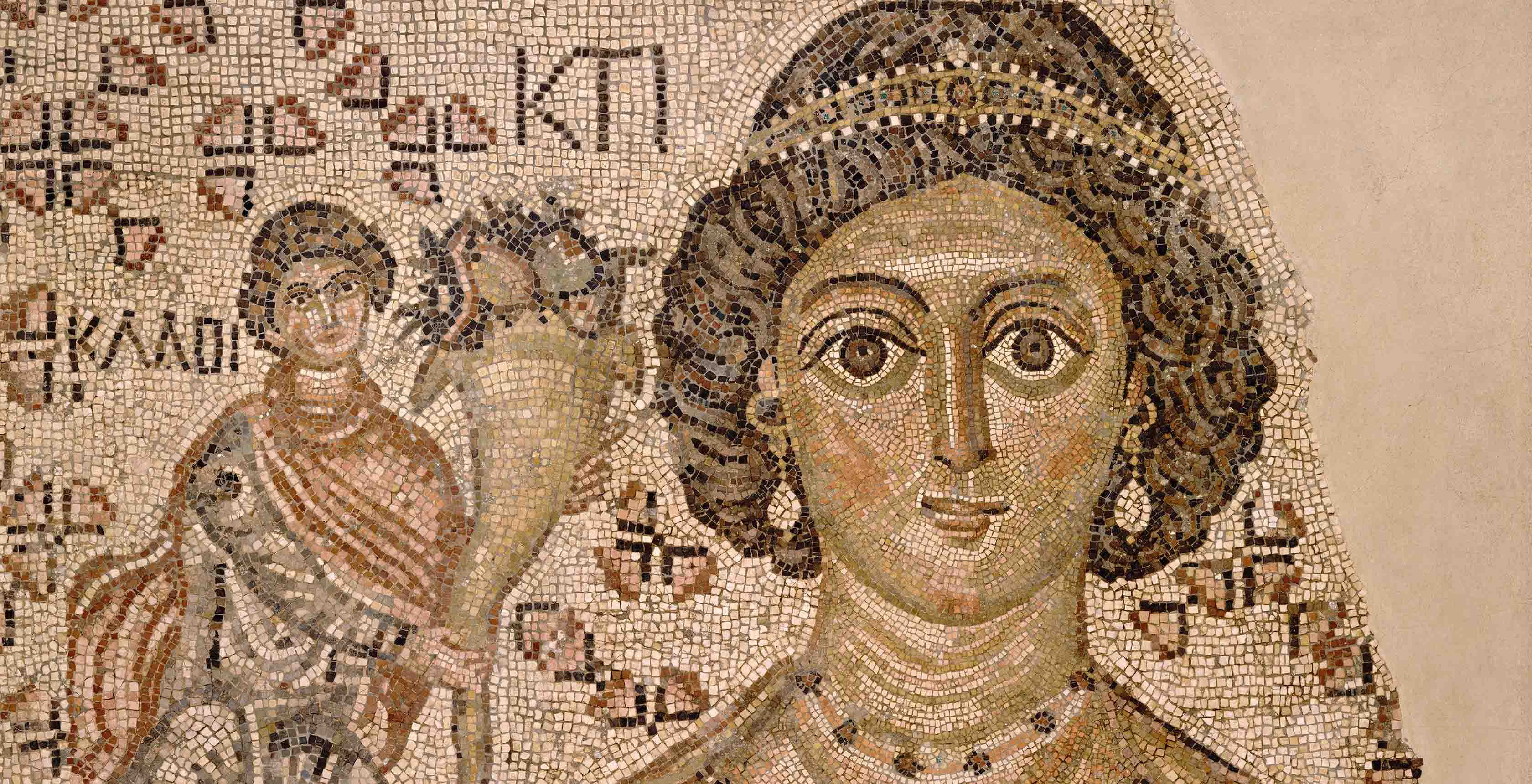 Brown and beige fragment of a floor mosaic with a brown-skinned woman with curly brown hair, a headpiece, and earrings at center, and a man smaller in scale presenting her flowers to her left