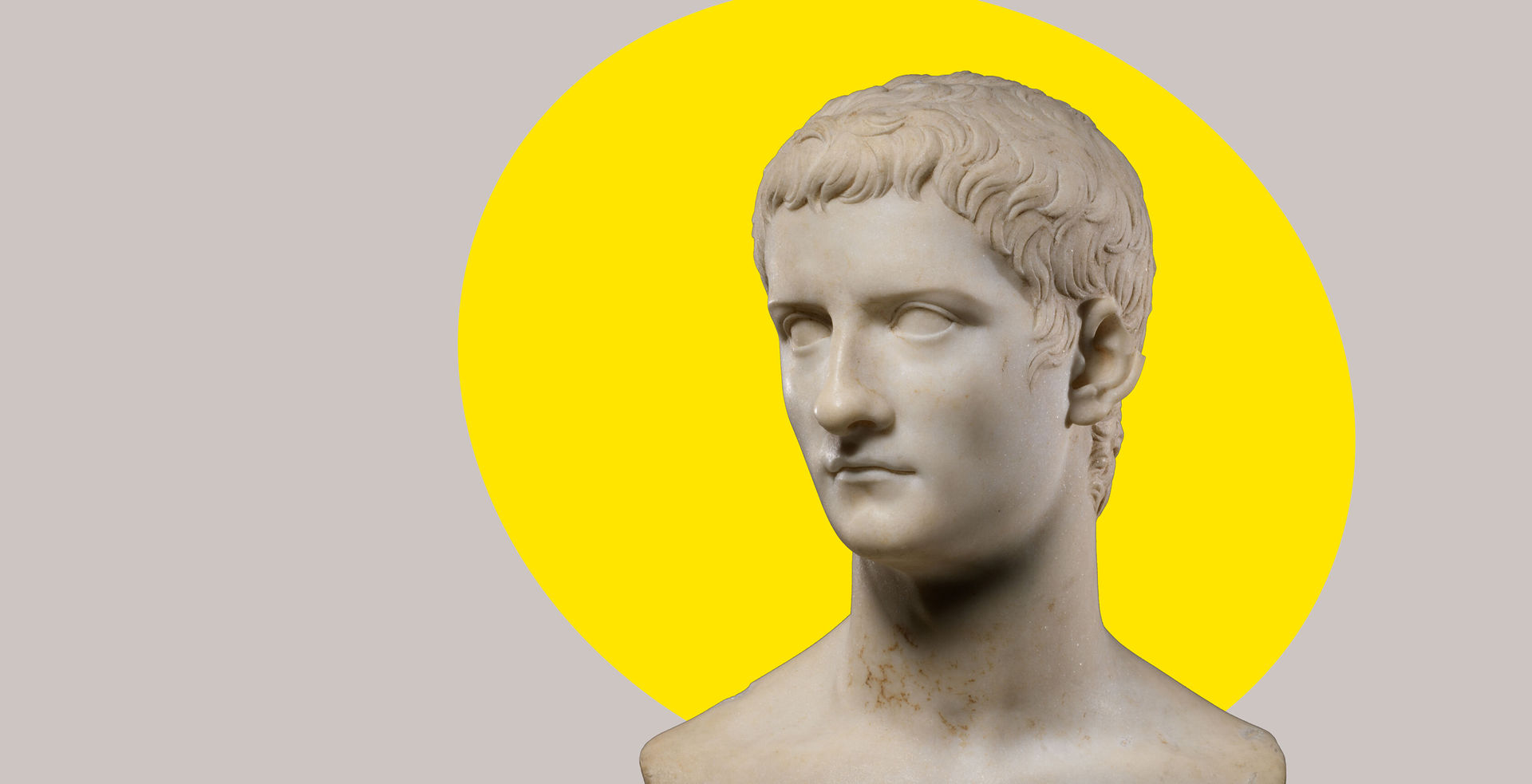Marble portrait bust of Caligula, with a bright yellow ovular spotlight shape behind the figure in the background