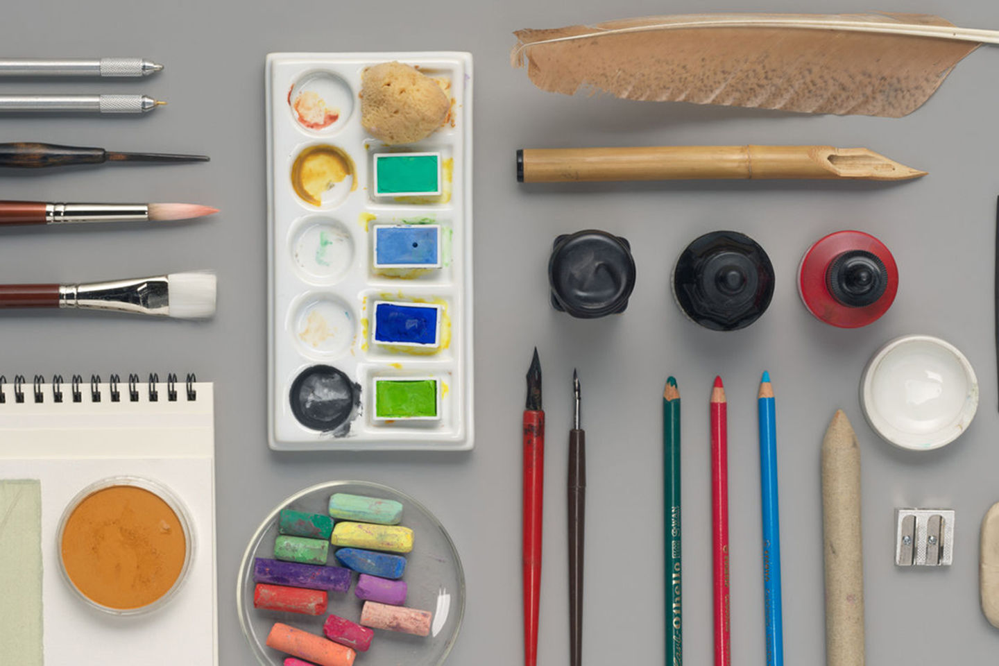 A variety of drawing tools, including pens, markers, brushes, and various inks and pigments.