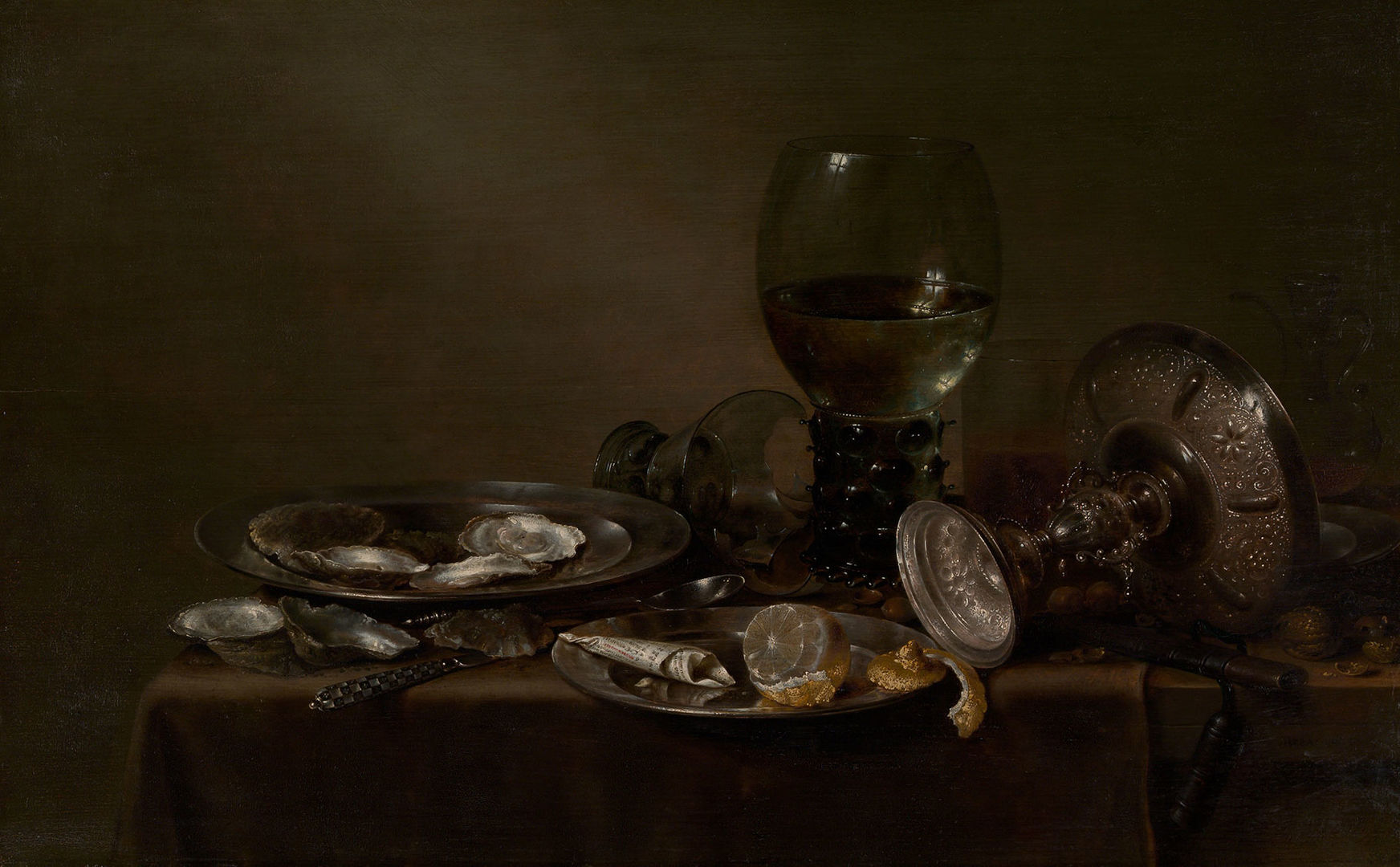In a dark room, oysters and lemons are laid out on a table. A silver tazza has been knocked over, and a glass cup has been broken.